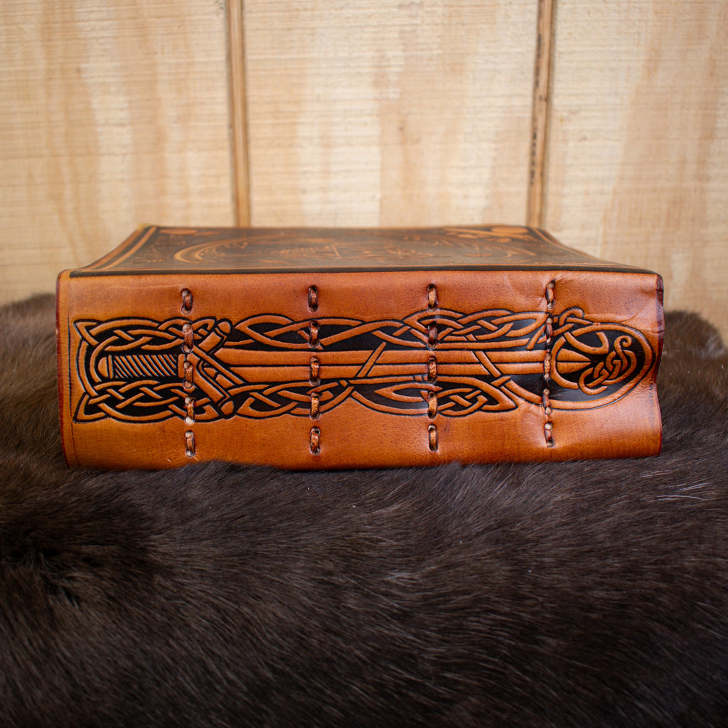 The spine of a tan leather spellbook journal featuring a sword