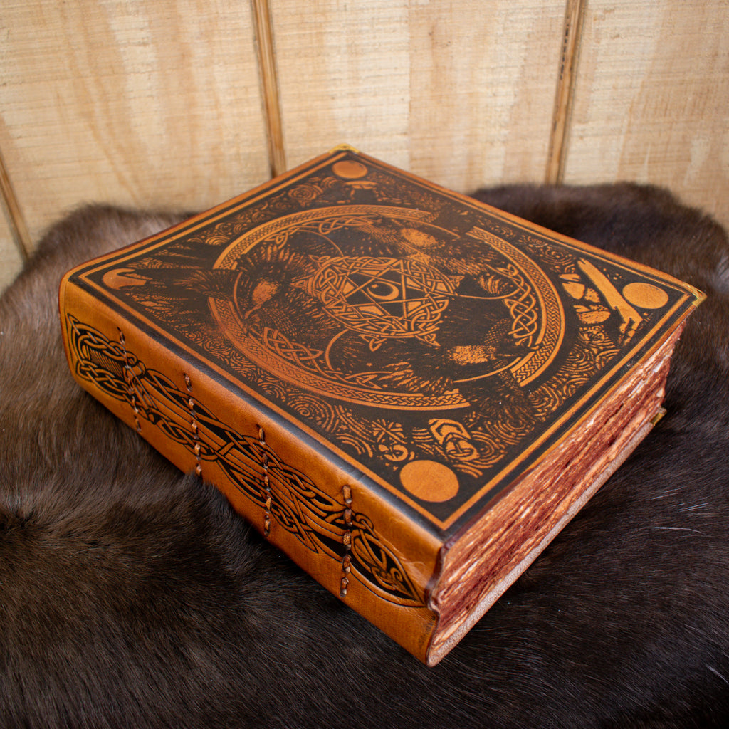 A large tan leather spell book journal featuring ravens and a pentacle