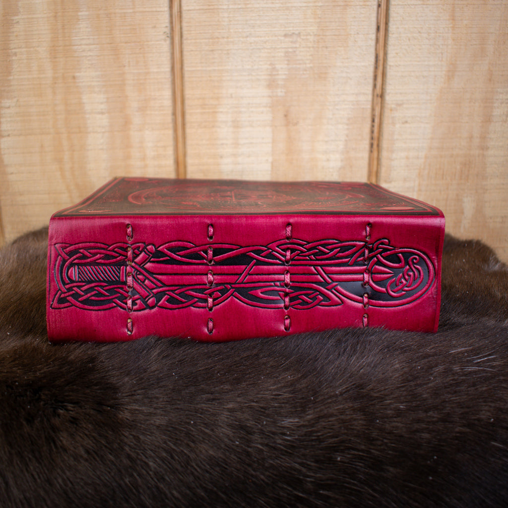 The spine of a red leather spell book journal featuring a sword