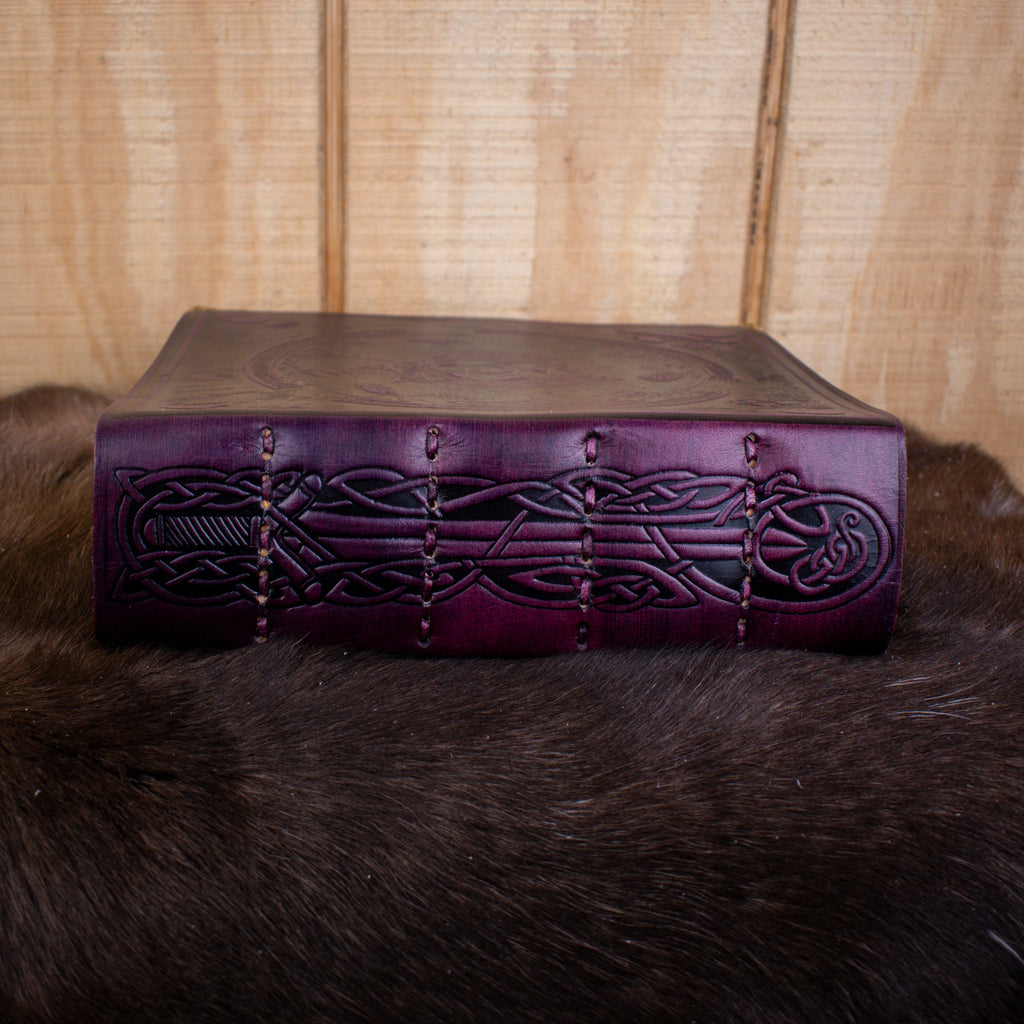 A large purple leather spell book journal featuring ravens and a pentacle