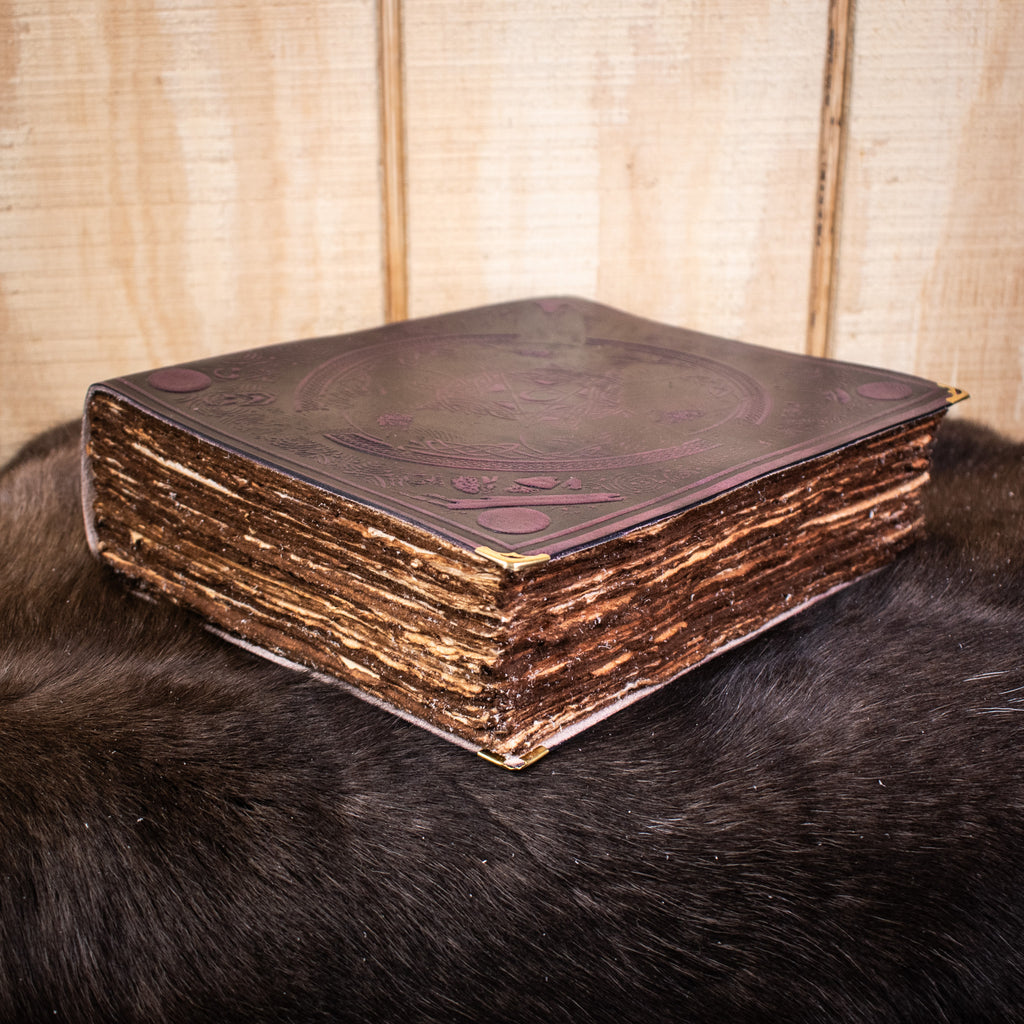 A large purple leather spell book journal featuring ravens and a pentacle