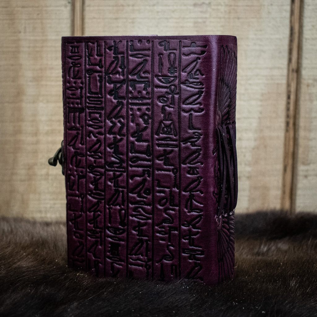 A purple leather journal featuring hieroglyphics