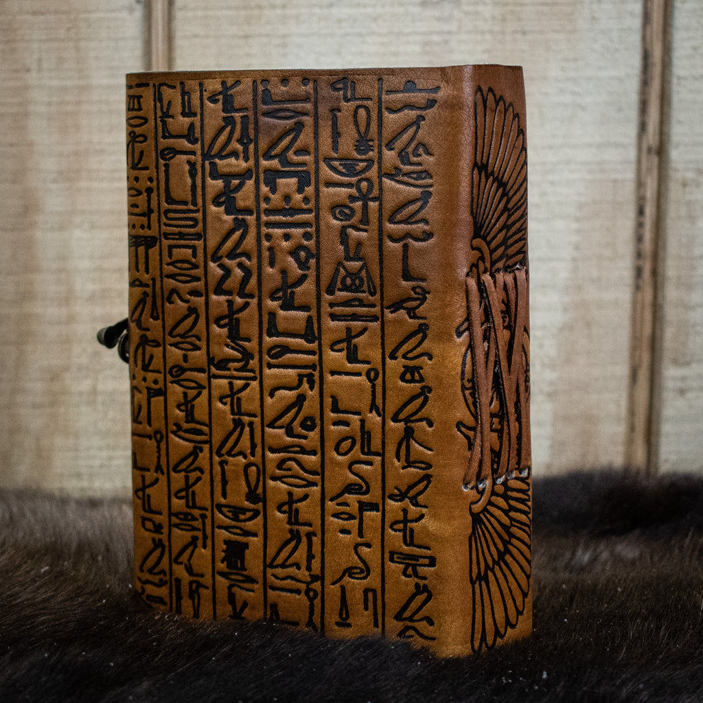 A tan leather journal featuring hieroglyphics