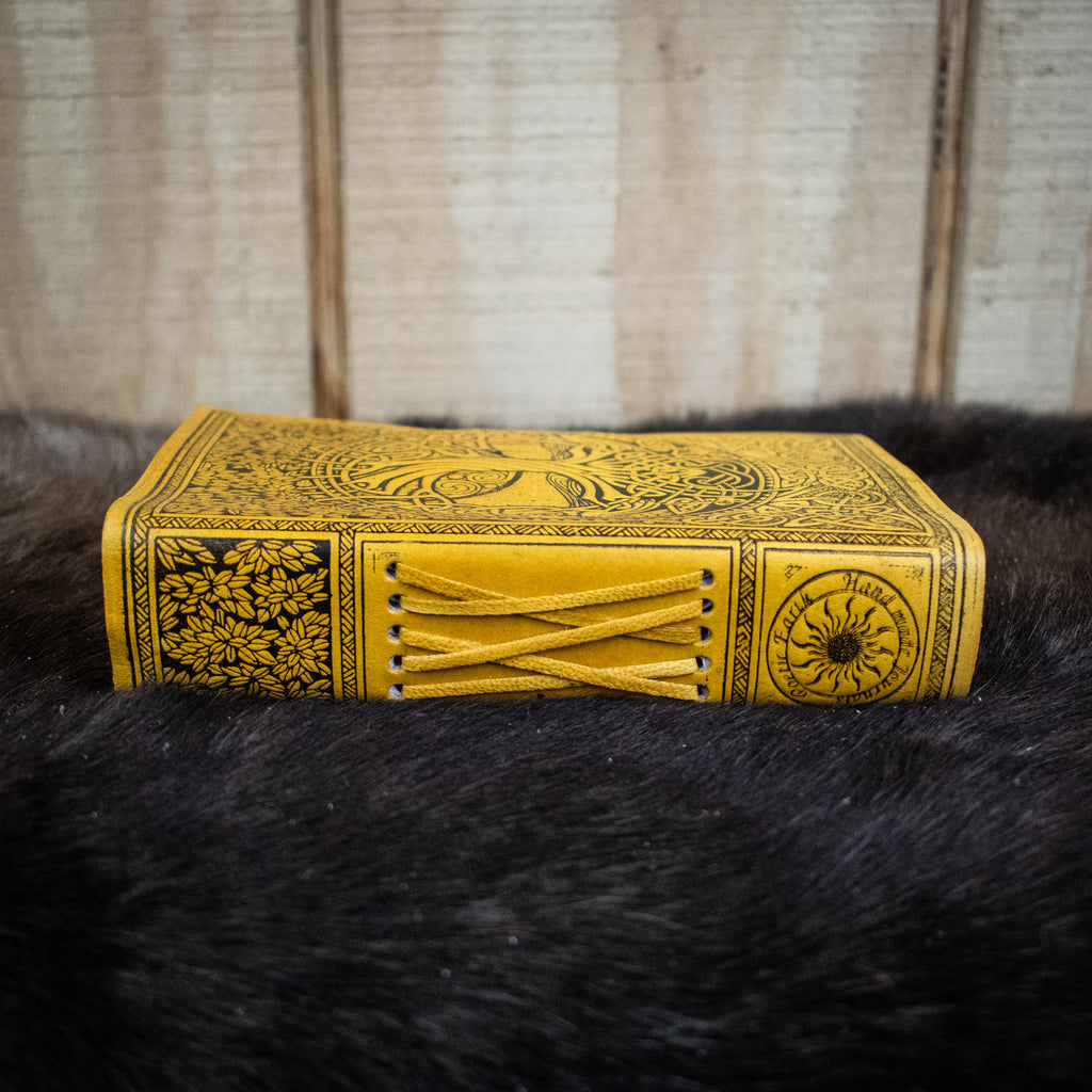 The spine of a yellow leather journal featuring the tree of life