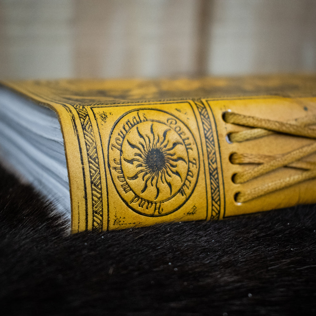 A yellow leather journal featuring the tree of life