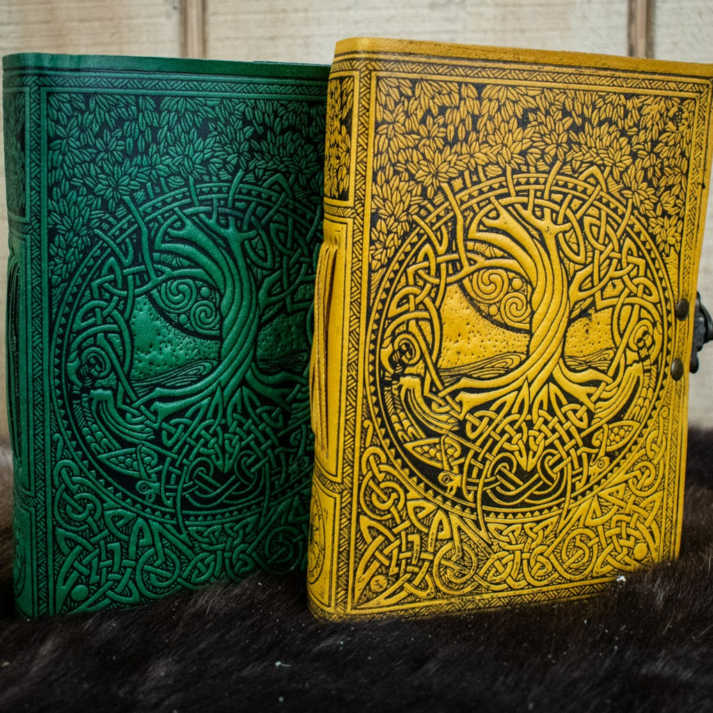 Two leather journals featuring the tree of life in green and yellow