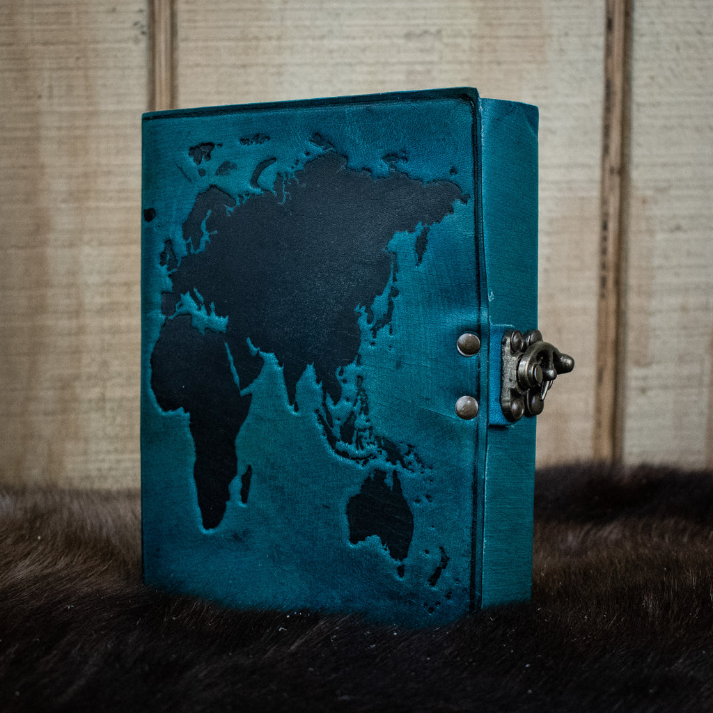 A blue leather journal featuring the world map