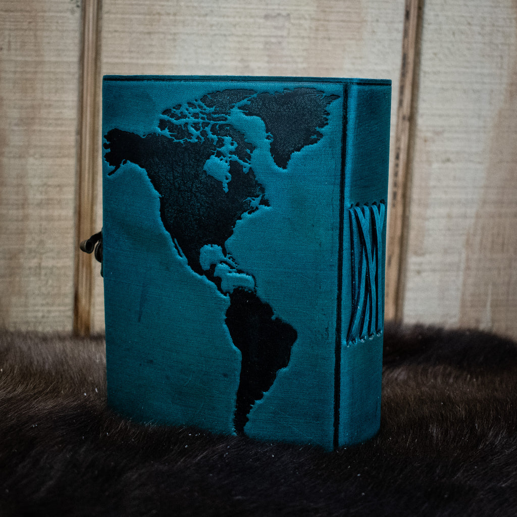 A blue leather journal featuring the world map