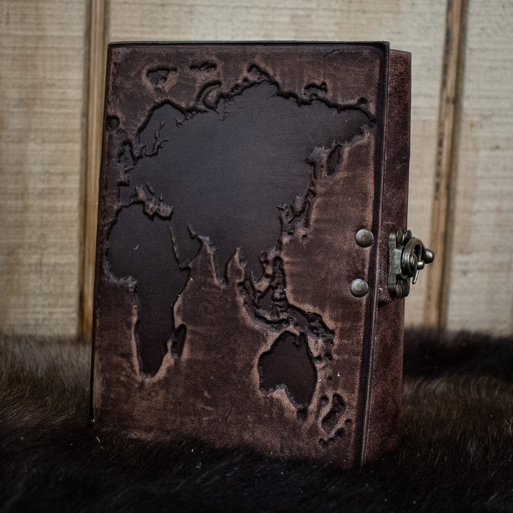 A dark brown leather journal featuring a world map