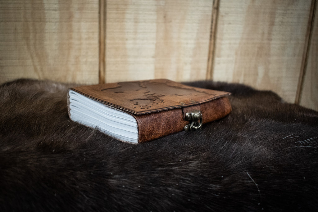 A light brown leather journal featuring a world map