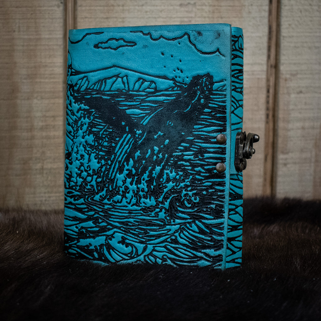 A blue journal featuring humpback whales