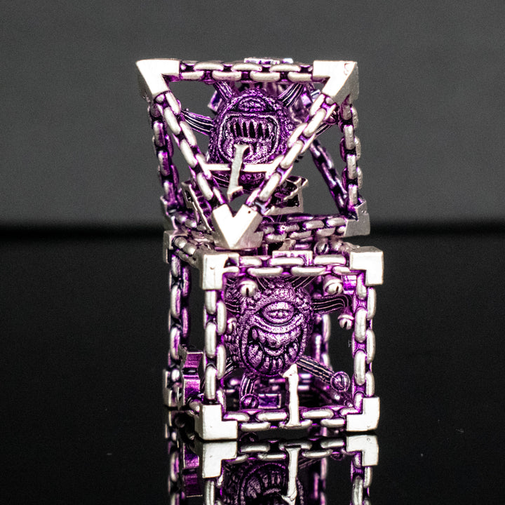 A set of hollow metal dice in purple and silver colors with embossed numbers and a beholder inside, reflecting on a shiny surface.