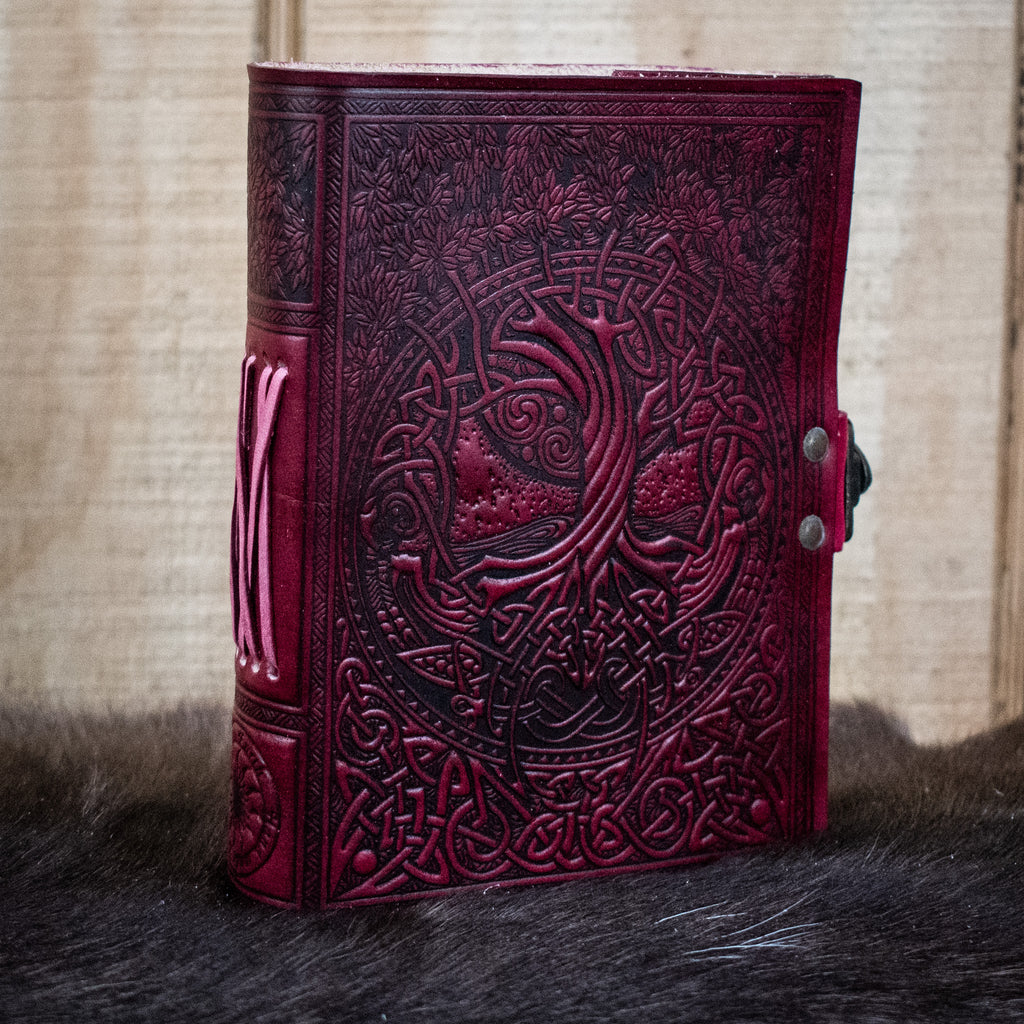 A red leather journal featuring the tree of life