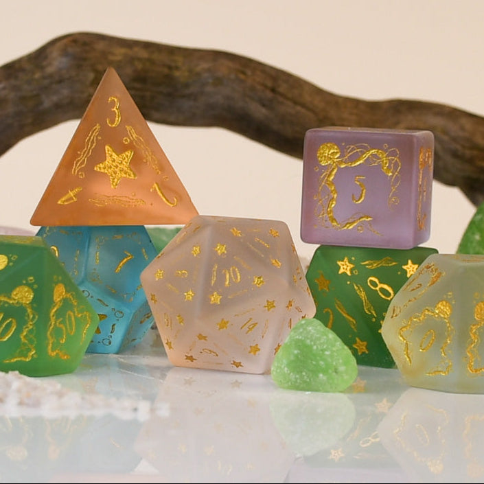 Set of colorful dice with star and moon designs on a neutral background