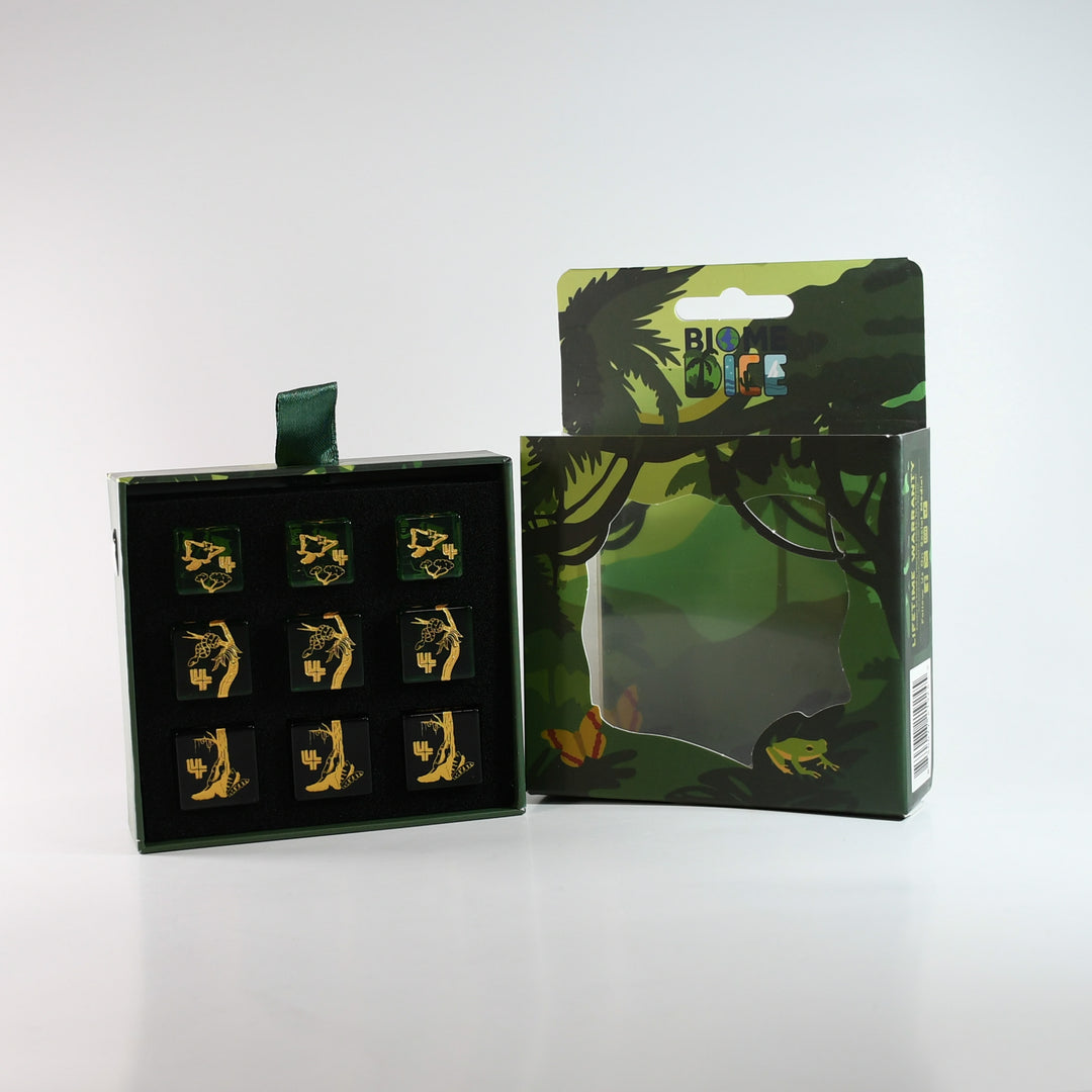 Set of gold figurines in a black box with a green and black branded box on a white background
