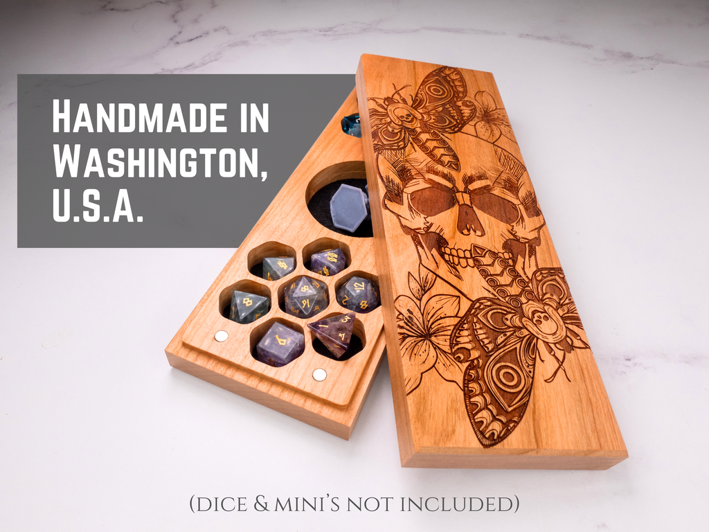 Wooden dice box with engraved skull and butterfly design on a marble surface, with text indicating 'Handmade in Washington, U.S.