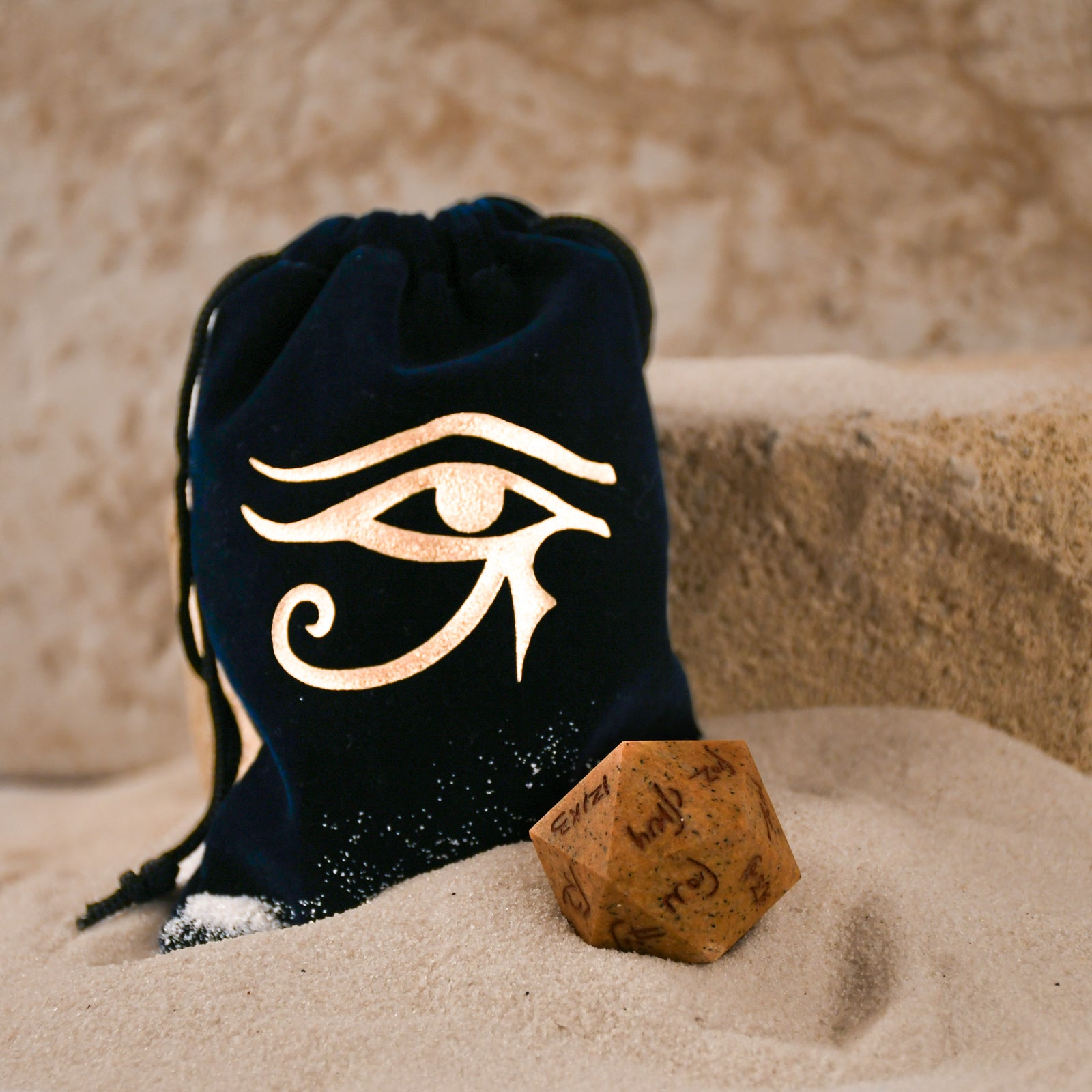 An oversized, inscribed limestone twenty-sided die, featuring Demotic script, displayed on a soft surface.