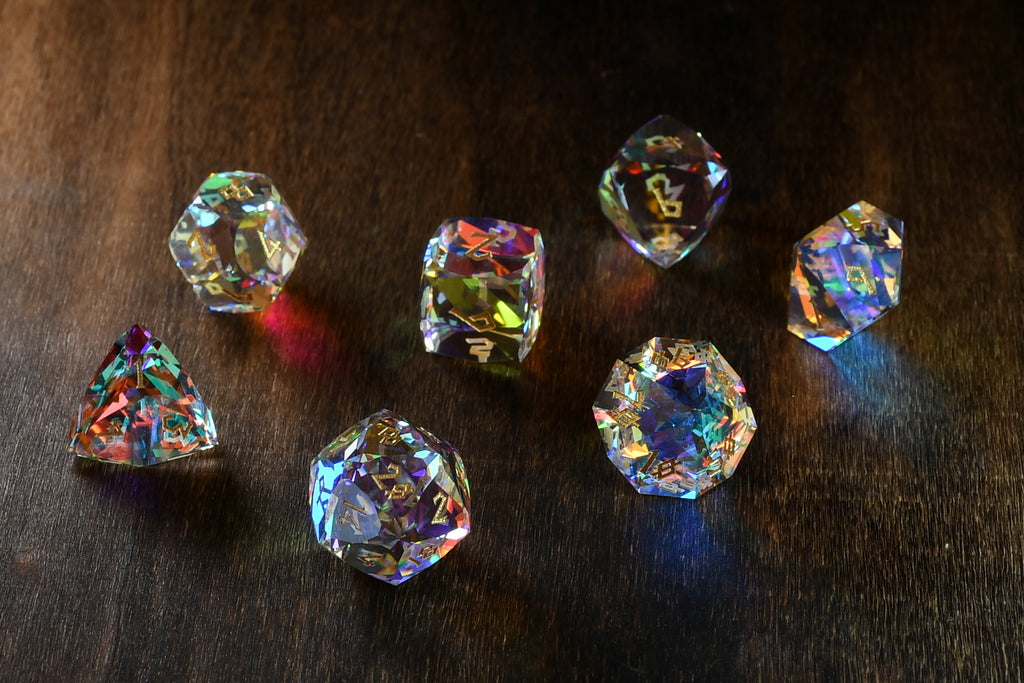 A close-up of a multifaceted, multicolored glass dice with engraved numbers, on a dark background.