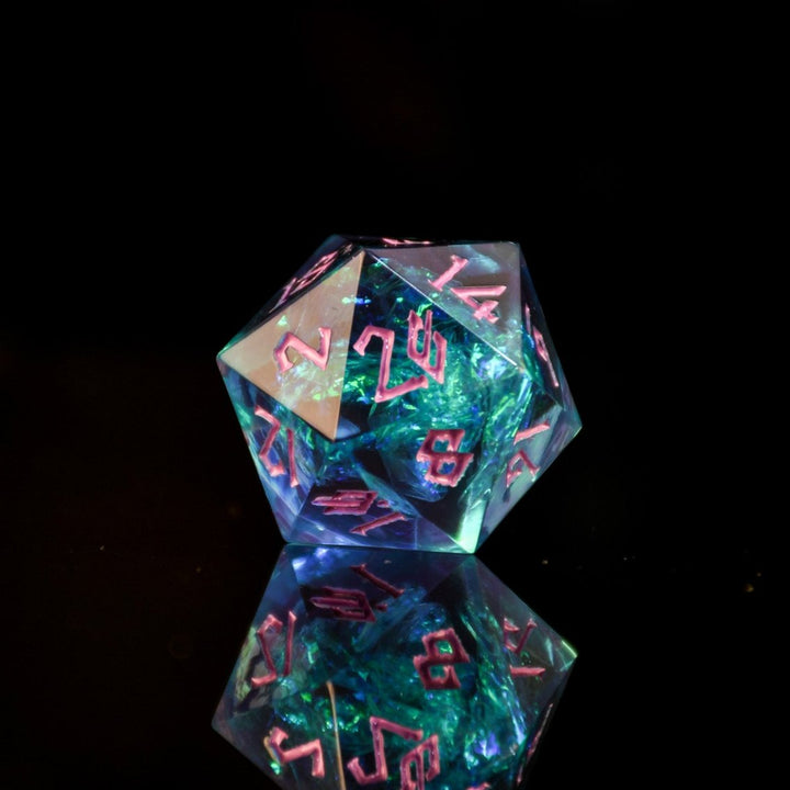 A set of sharp-edged, multicolored resin dnd dice with pink hand-painted numbers, reflecting a vibrant blue, green and purple glow.