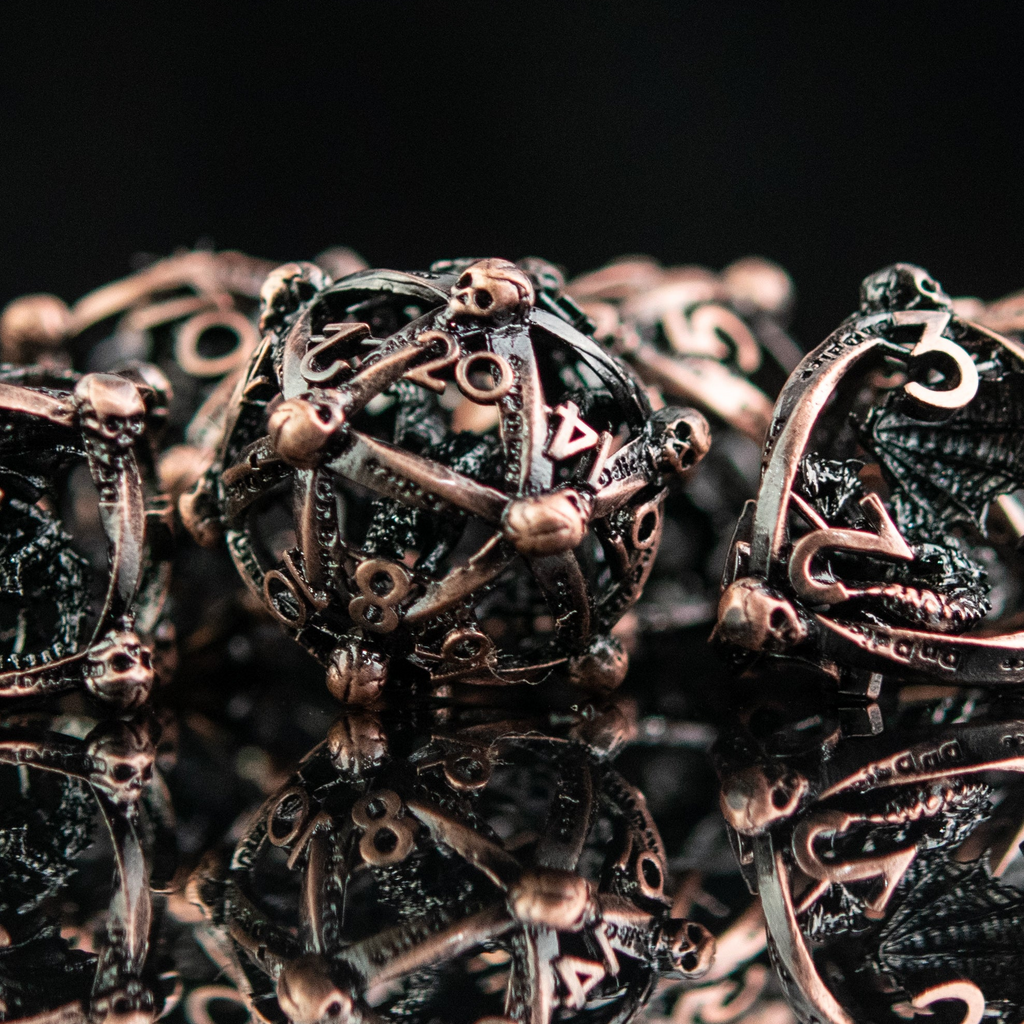 Close-up of ornate bronze dice and gaming pieces on a reflective surface with a dark background.