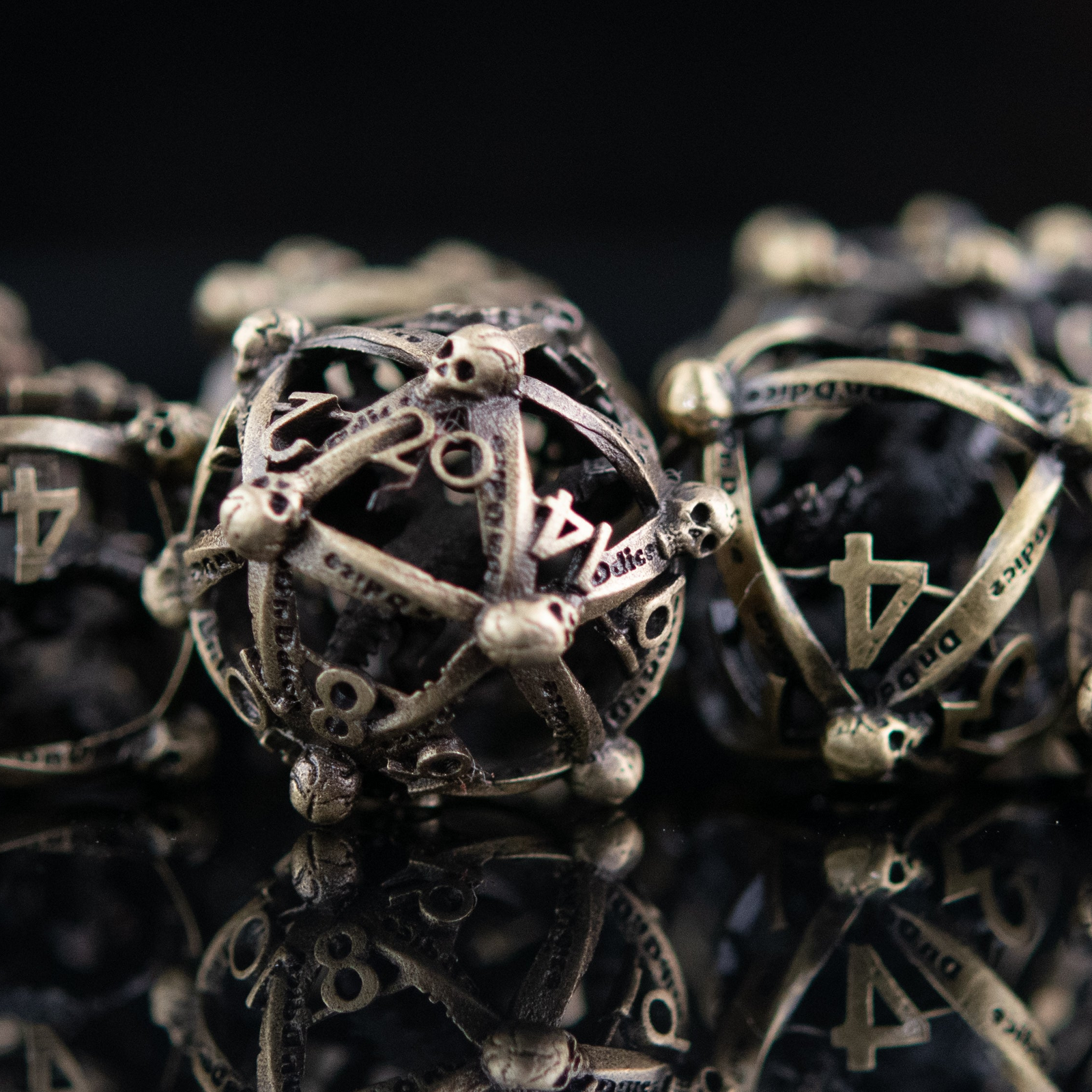 Close-up of hollow metal dice that are bronze with skulls at each corner