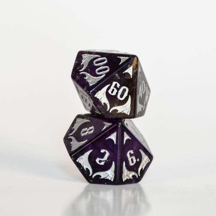 Two polyhedral dice with black and silver design on a white background
