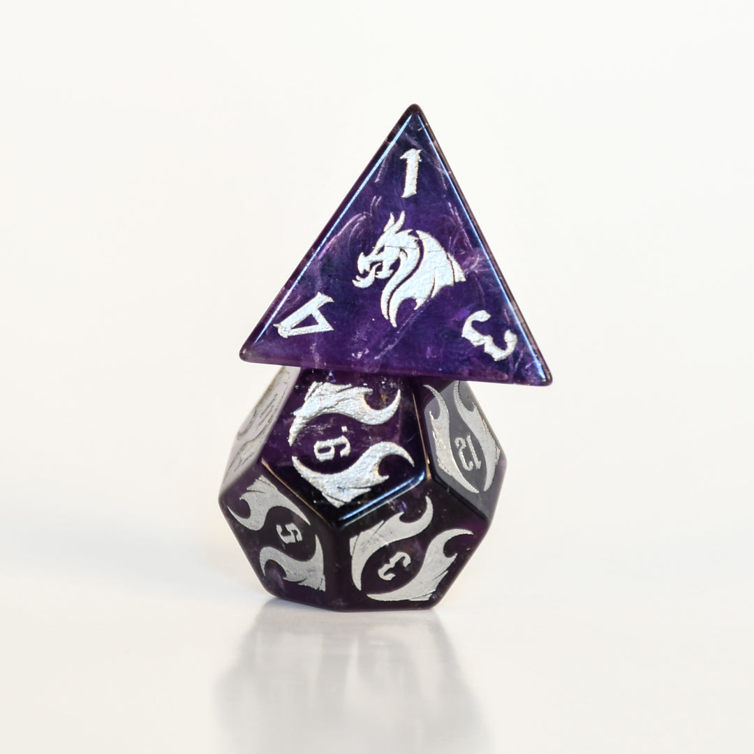 Purple and silver polyhedral dice set on a white background