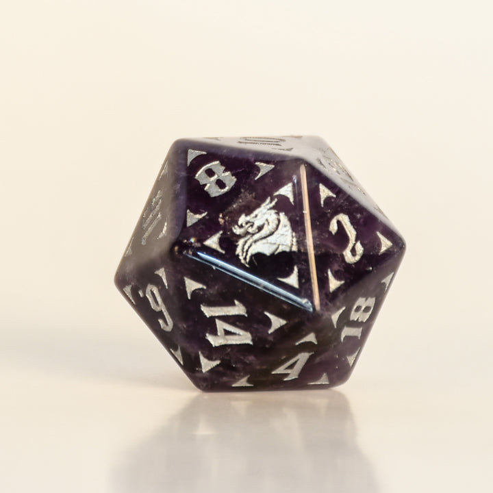 D20 polyhedral dice with a dragon emblem on a beige background