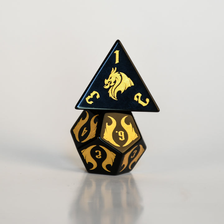 Black and gold polyhedral dice with dragon design on a light gray background