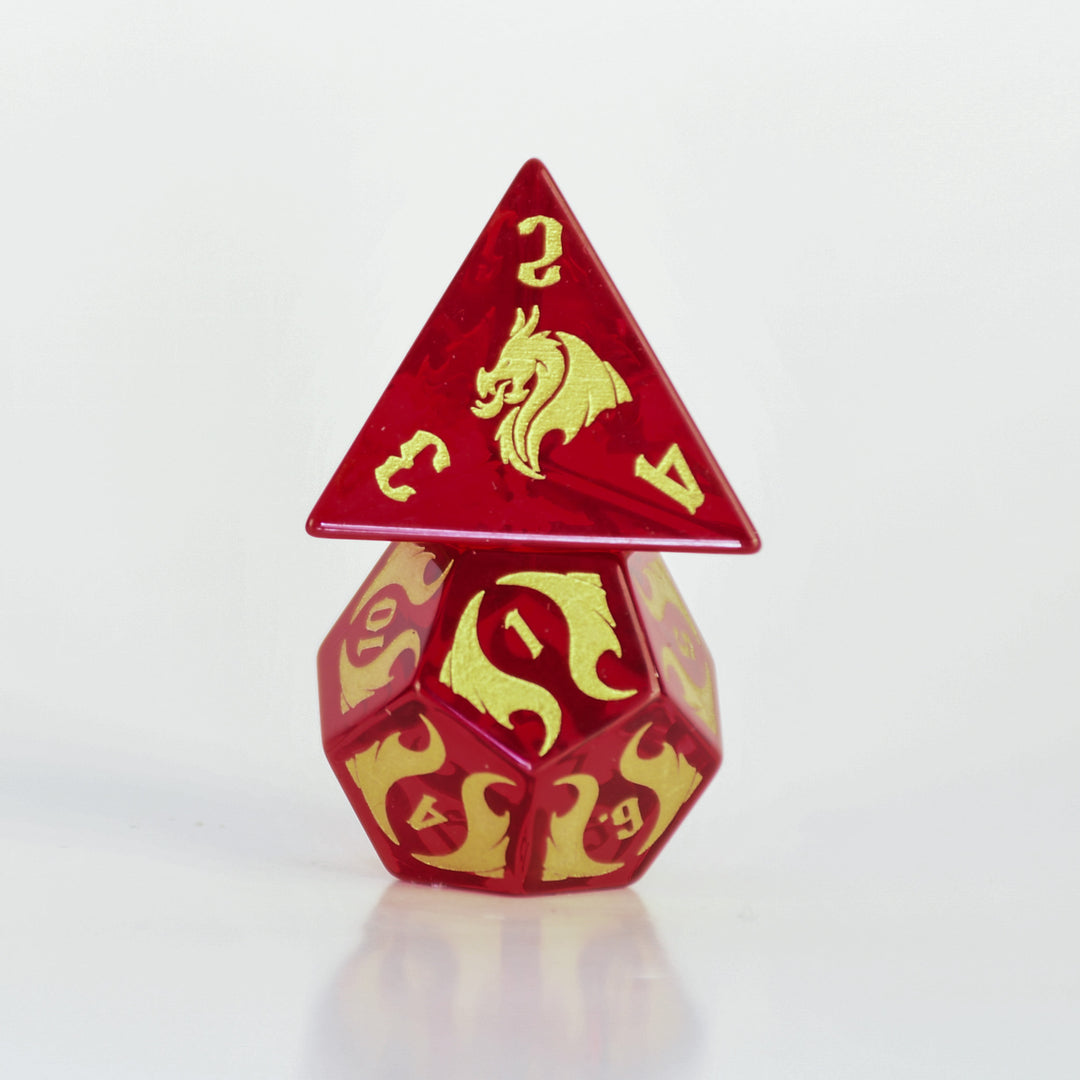 Set of red and gold polyhedral dice with dragon design on a dark background