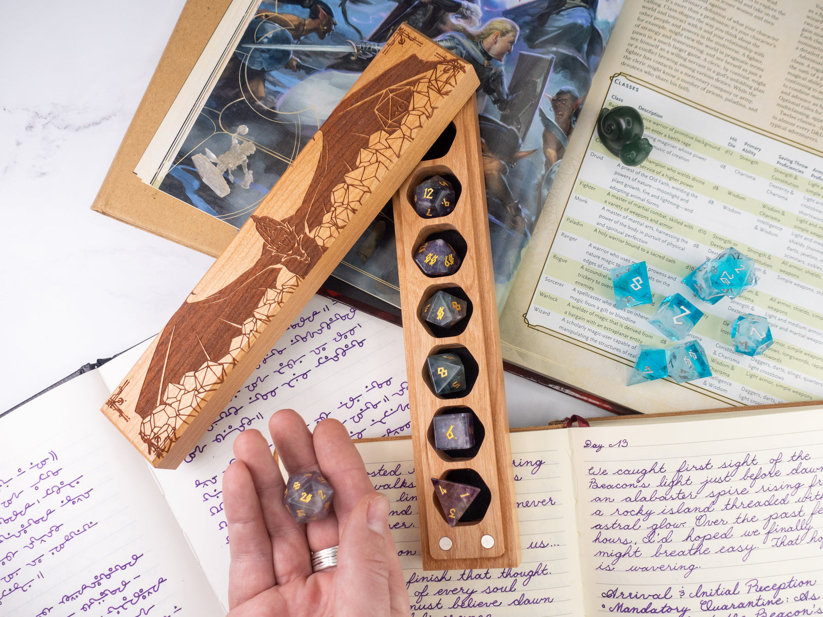 Wooden dice holder with engraved design on a table with gaming materials