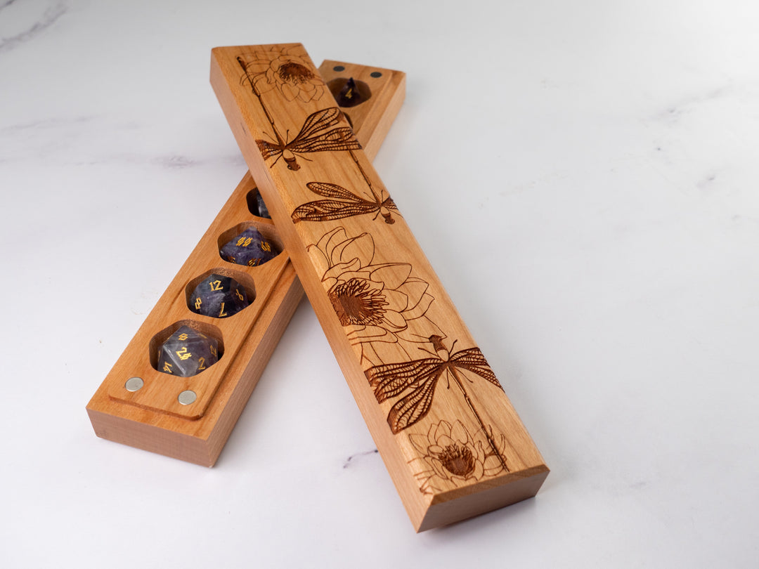 Wooden dice tray with laser-engraved designs on a white background