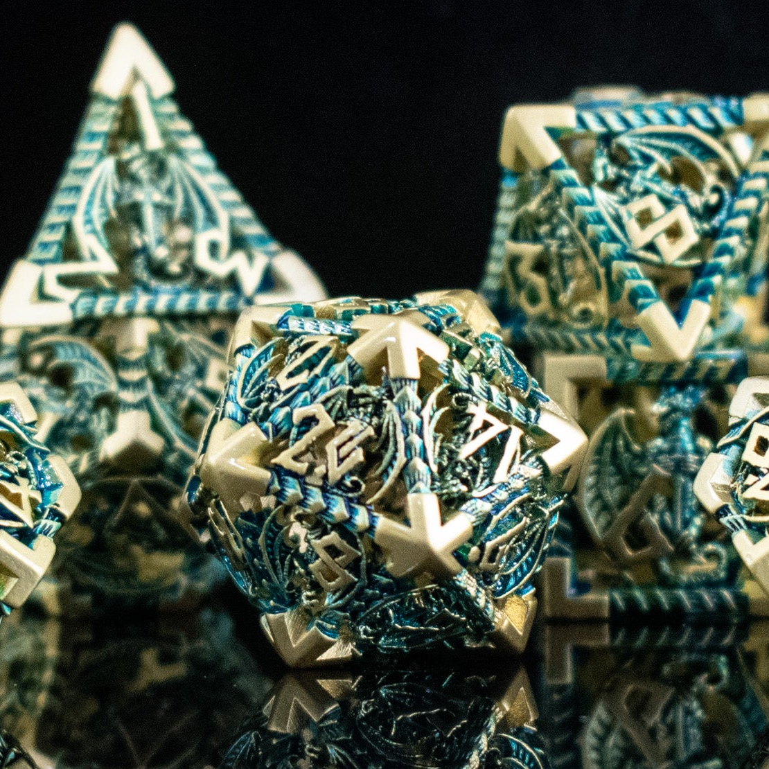 A set of embossed metal hollow dice in blue and gold colors, displayed on a reflective surface.