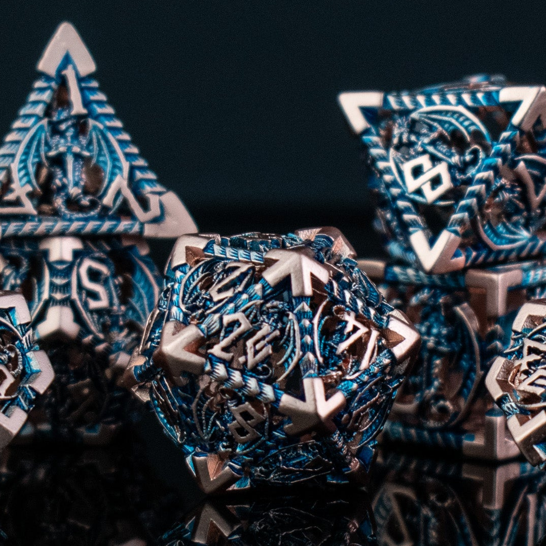 A set of embossed metal hollow dice in cobalt and bronze colors, displayed on a reflective surface.