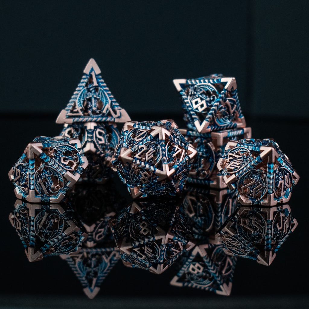 A set of embossed metal hollow dice in cobalt and bronze colors, displayed on a reflective surface.