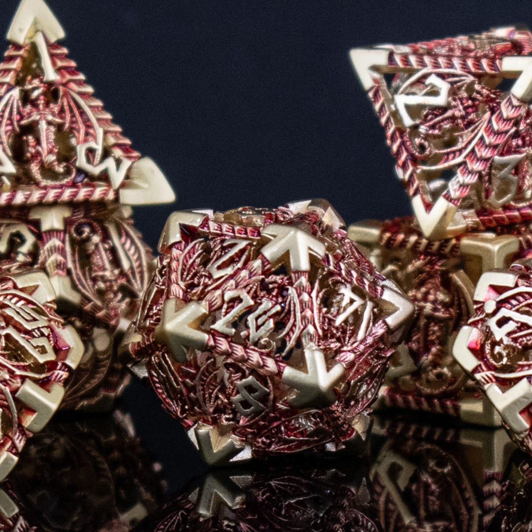 A set of embossed metal hollow dice in gold and red, with dragons displayed on a reflective surface.