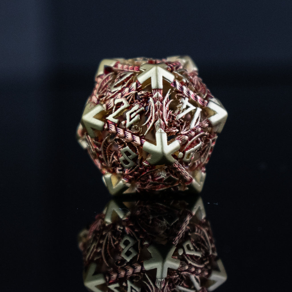 A set of embossed metal hollow dice in gold and red, with dragons displayed on a reflective surface.