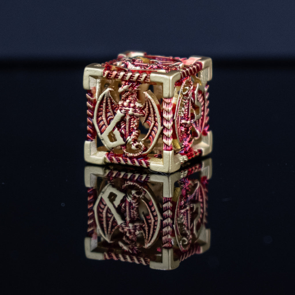 A set of embossed metal hollow dice in gold and red, with dragons displayed on a reflective surface.