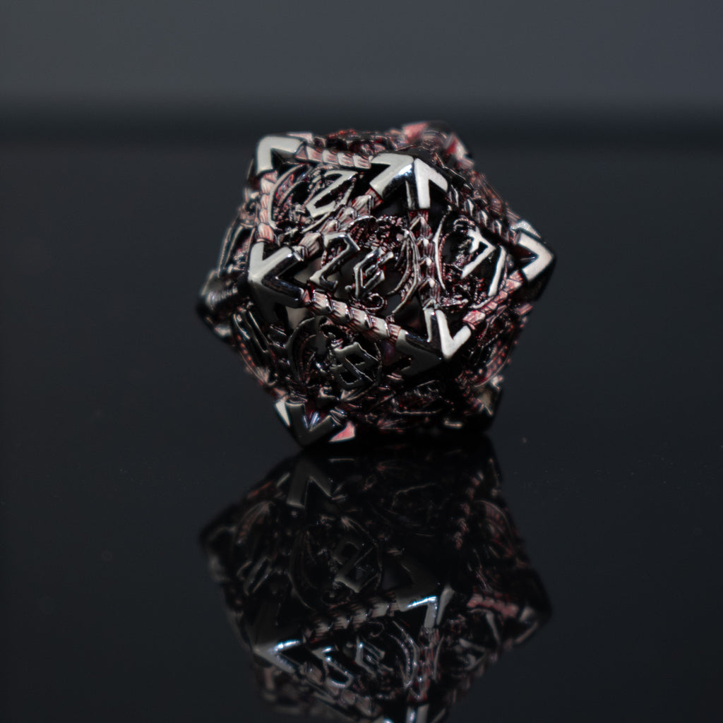 A set of embossed metal hollow dice in crimson and shadow colors, including various shapes such as a d4, d6, d8, d10, d12, and d20, displayed on a reflective surface.