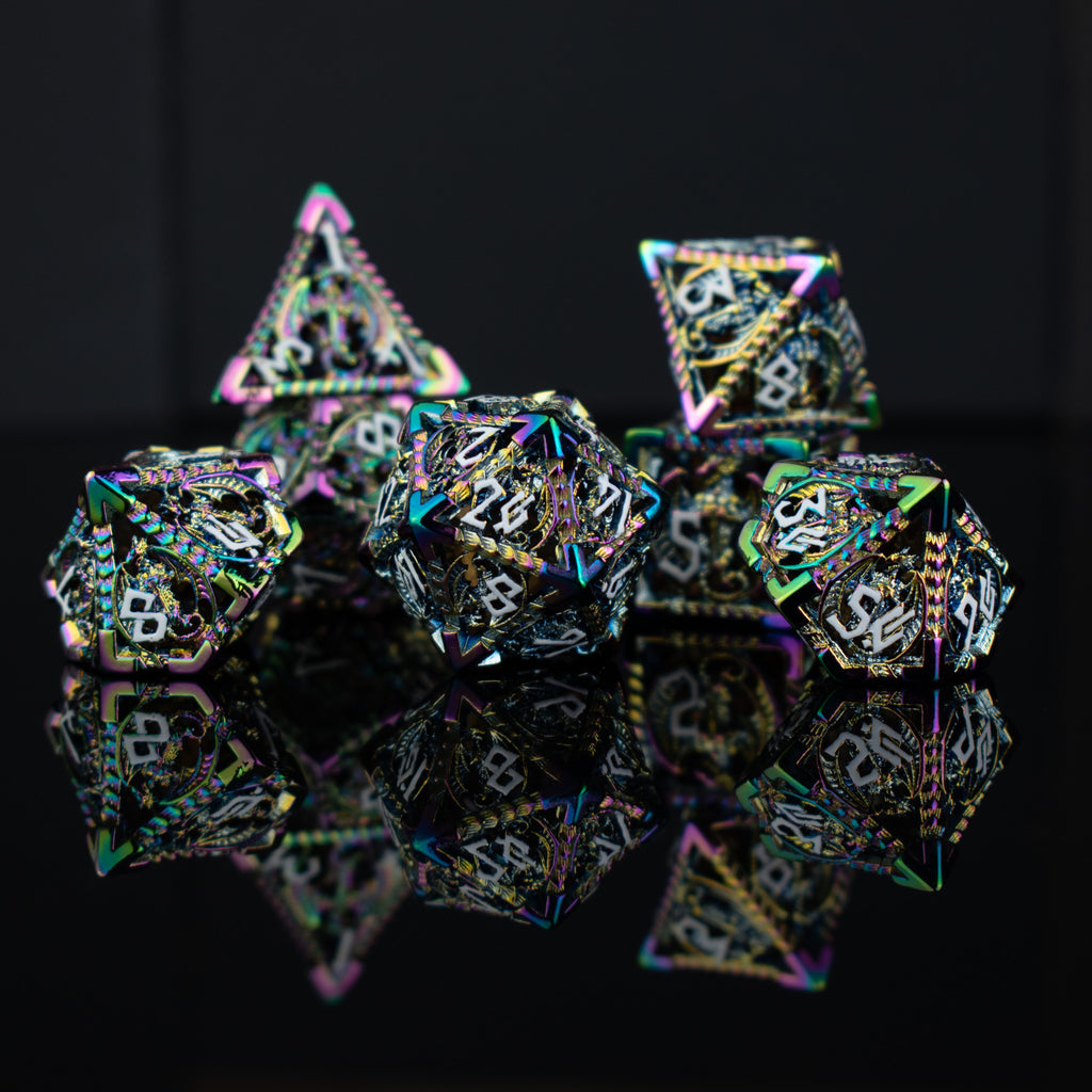A set of embossed metal hollow dice with iridescent colors reflecting light, placed on a dark reflective surface.