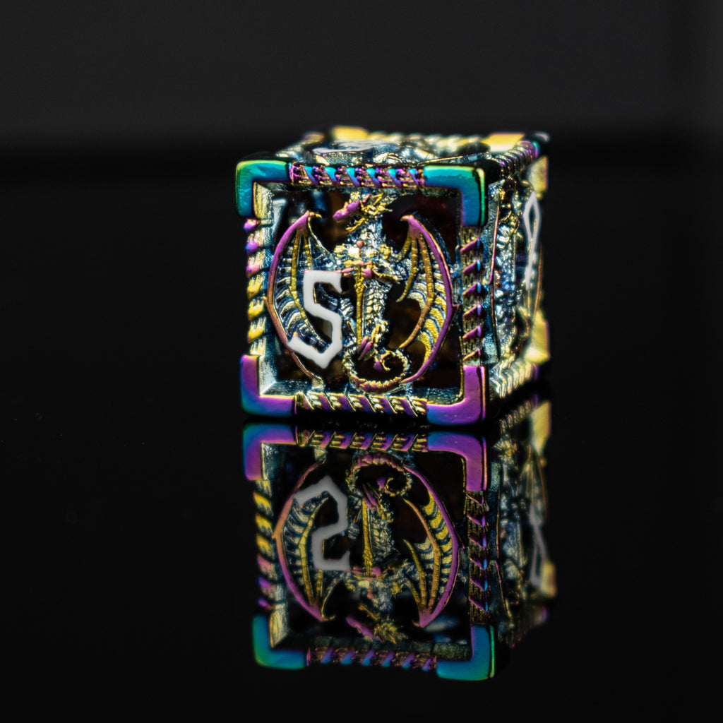 A set of embossed metal hollow dice with iridescent colors reflecting light, placed on a dark reflective surface.