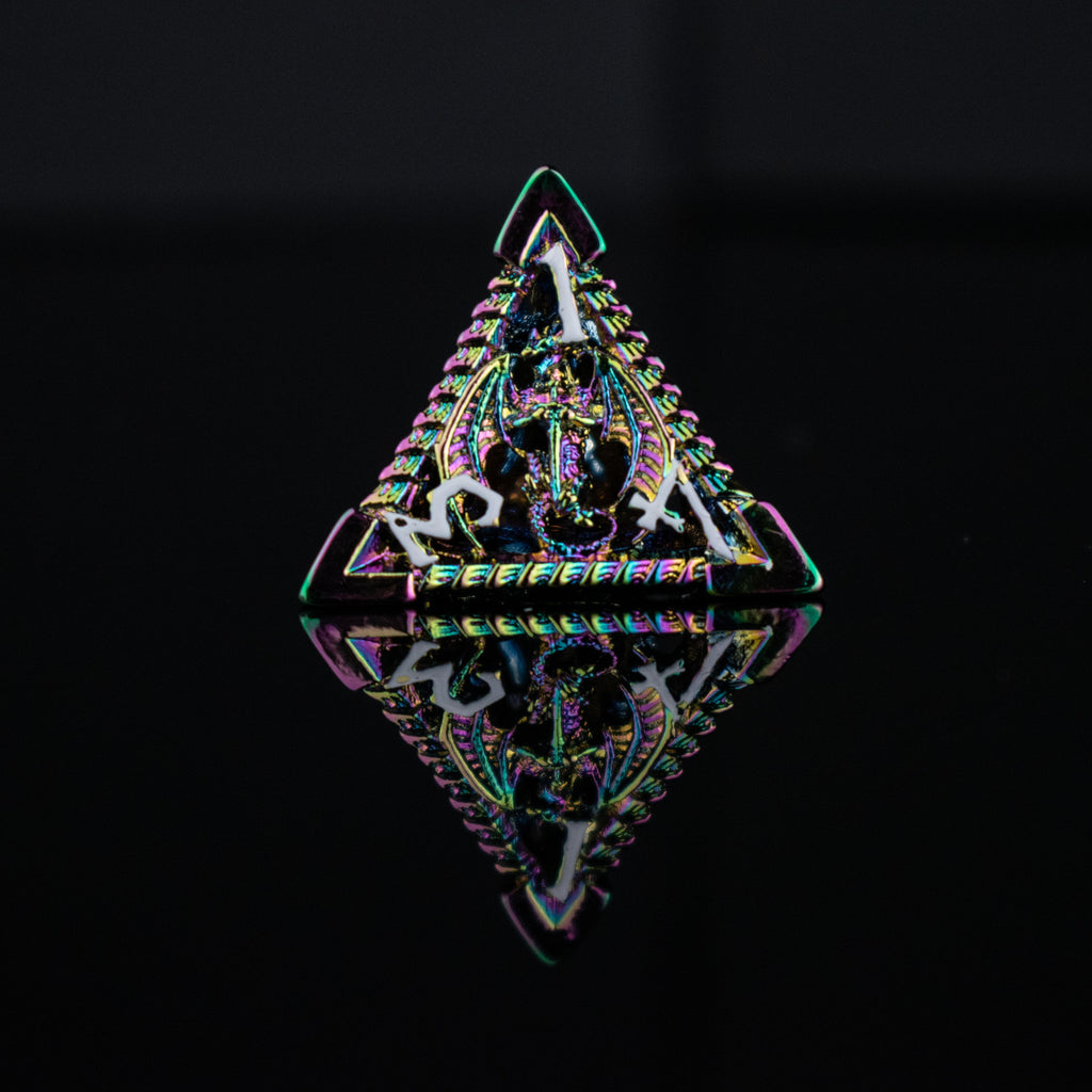 A set of embossed metal hollow dice with iridescent colors reflecting light, placed on a dark reflective surface.