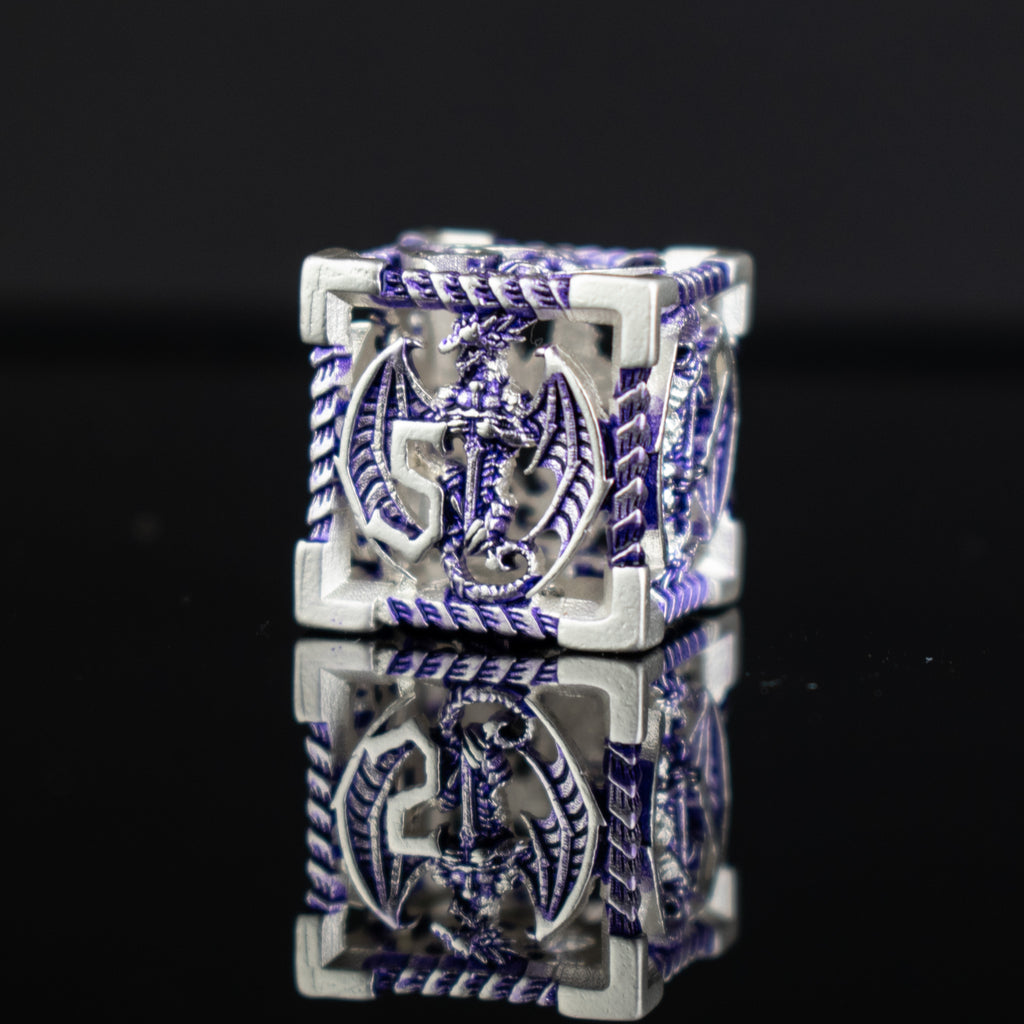 A set of embossed metal hollow dice in purple and silver, displayed on a reflective surface.