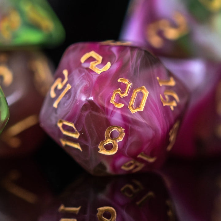 A set of multicolored acrylic dice with engraved numbers, including various shapes such as a d4, d6, d8, d10, d12, and d20, commonly used for RPGs.