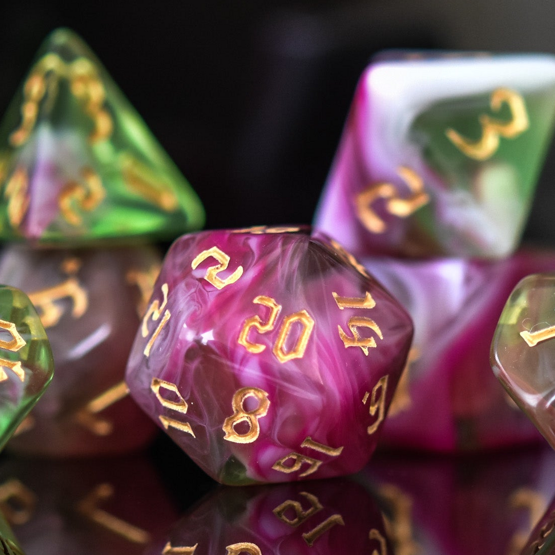 A set of multicolored acrylic dice with engraved numbers, including various shapes such as a d4, d6, d8, d10, d12, and d20, commonly used for RPGs.
