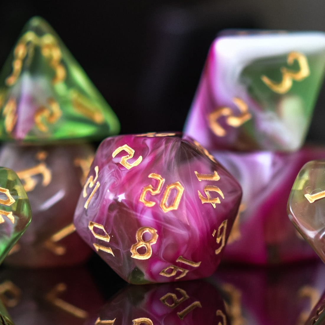 A set of multicolored acrylic dice with engraved numbers, including various shapes such as a d4, d6, d8, d10, d12, and d20, commonly used for RPGs.