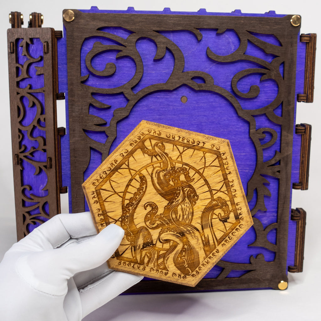 A selection of four compact dungeon master screens in various colors, each featuring a filigree pattern and brass fixtures, with magnetic acrylic panels for displaying maps and notes.