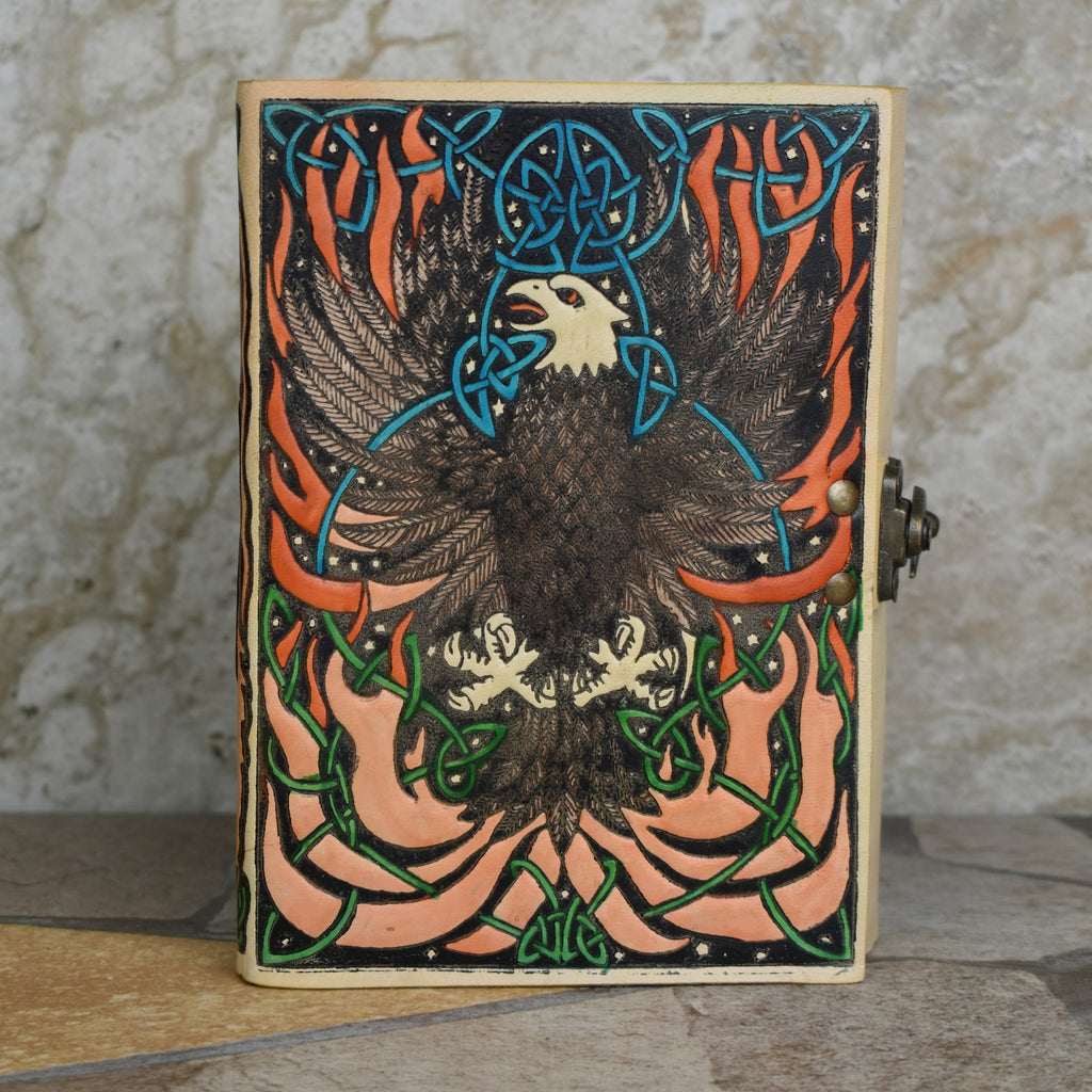 A hand-bound leather adventure journal with a full-grain goat leather cover featuring a Celtic inspired painted eagle design in brown, blue, and green.
