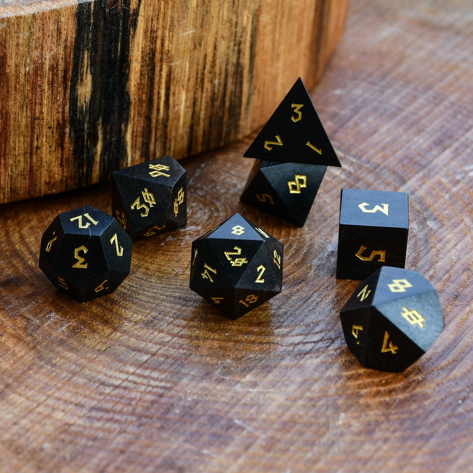black wooden dice with gold numbers for dnd
