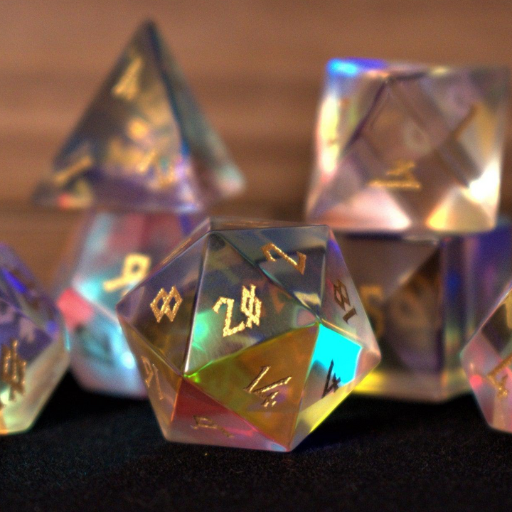 A set of iridescent glass dice with engraved numbers, including various shapes such as a four-sided die (D4), six-sided die (D6), eight-sided die (D8), ten-sided dice (D10), twelve-sided die (D12), and twenty-sided die (D20).